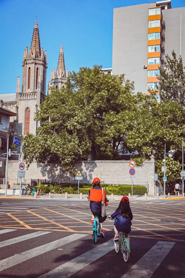Kids biking through Beijing streets with historic architecture and local neighborhood views