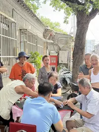 Tourists and locals playing majhong at beijing hutong