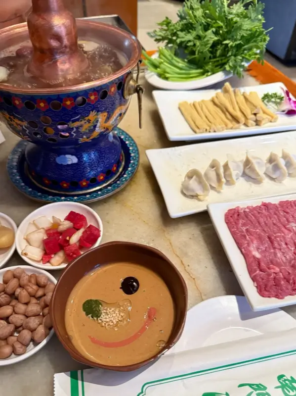 Full table setting with Mutton Hotpot, dipping sauce, and side dishes.