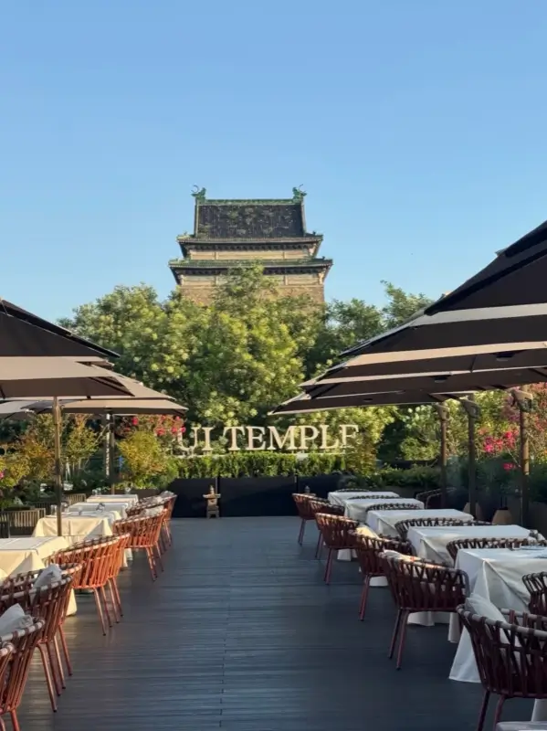 Outdoor courtyard with seating and a view of the ancient city tower at Hong'en Guan.