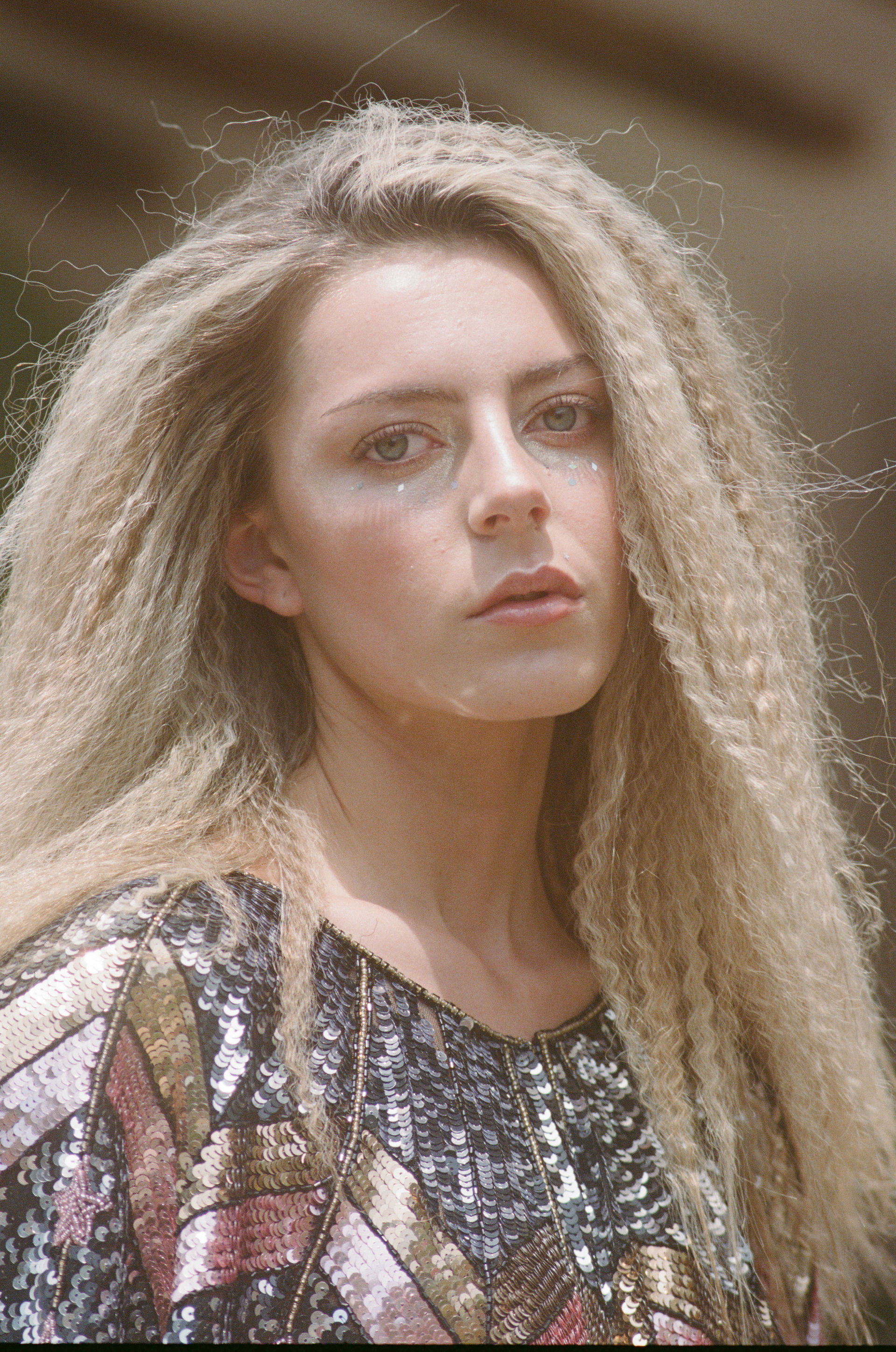 A girl with crimped blonde hair stares into the camera