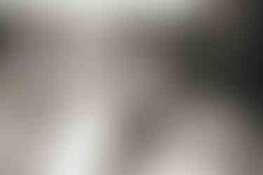 A black and white image of a blonde haired lady wearing a white brimmed hat for The Photographer, the Muse & the Quiet Truth of Time