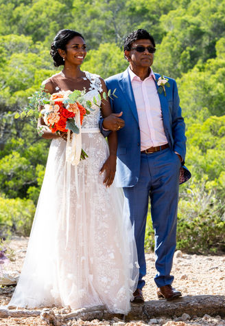 a man in a blue suit walks a bride down the aisle