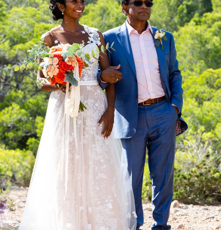 a man in a blue suit walks a bride down the aisle