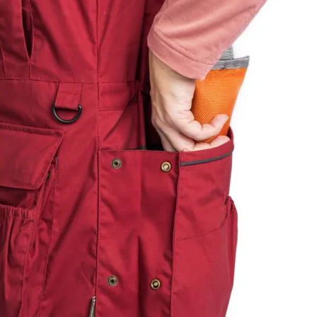 Thumbnail: Image shows a woman putting a dummy into the large rear pocket of the vest. The vest is red.