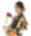 黒地にオレンジと黄色のバラ柄の振袖を着た女性が赤い花を手に持ち、横を向いてポーズをとっている成人式の写真