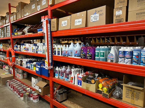 Red shelves stocked with cleaning supplies and paints