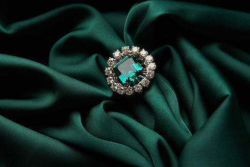 Emerald ring with clear stones on green satin