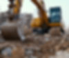 Yellow excavator digging construction debris