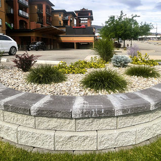 Curved stone retaining wall with decorative landscaping