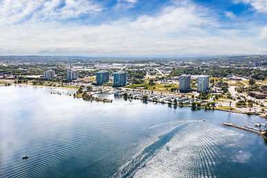 Aerial view of city waterfront, buildings, marina, and boat