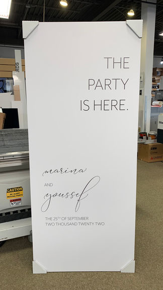 White event sign: 'The Party Is Here. Matilda and Youssef. 10.07.23 - 6:00PM 123 Event Hall - London.'