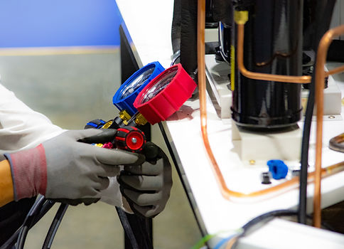Technician using manifold gauges on HVAC equipment