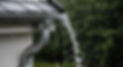 Rainwater overflowing from a house eavestrough during a storm