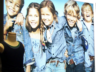 Five smiling children in denim jackets and jeans