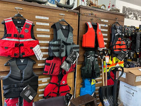 Red, black, and orange life jackets on display.