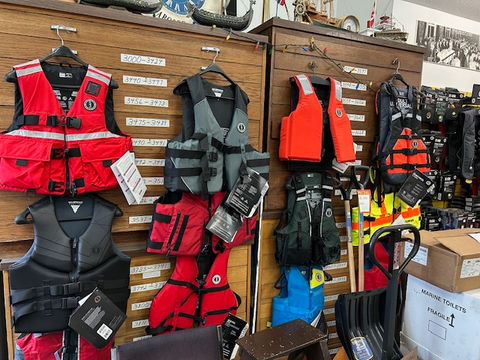 Red, black, and orange life jackets on display.