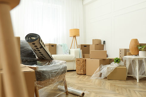 Packed boxes and rolled rug in a bright room for moving.