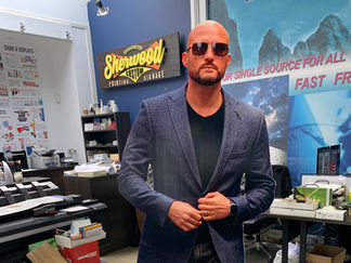 Man in sunglasses and blazer standing in an office