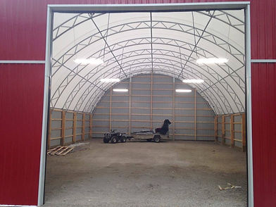Interior commercial wiring and lighting in a large metal shed.
