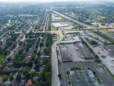 Aerial view of suburban landscape with homes, roads, commercial buildings