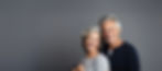 portrait of middle-aged couple smiling and hugging and looking at camera