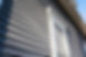 Dark gray horizontal lap siding on a house with white window trim