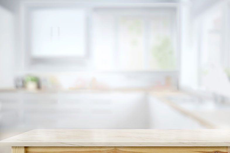 Light wooden countertop with blurred kitchen cabinets
