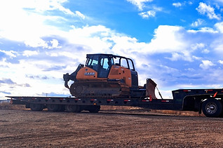 White semi-truck hauling bulldozer