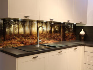 Kitchen backsplash with forest scene, sink, and cooktop