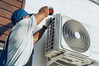 Technician installing an outdoor air conditioning unit