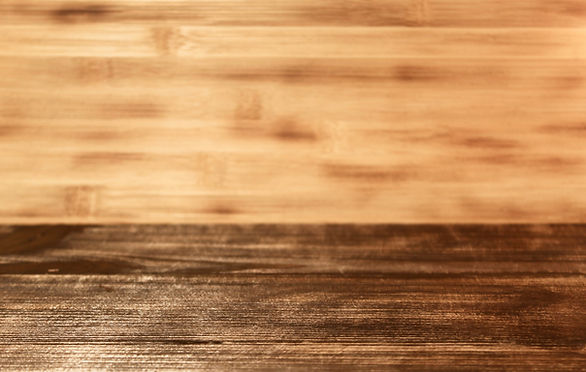 Polished dark wood surface against light timber background.
