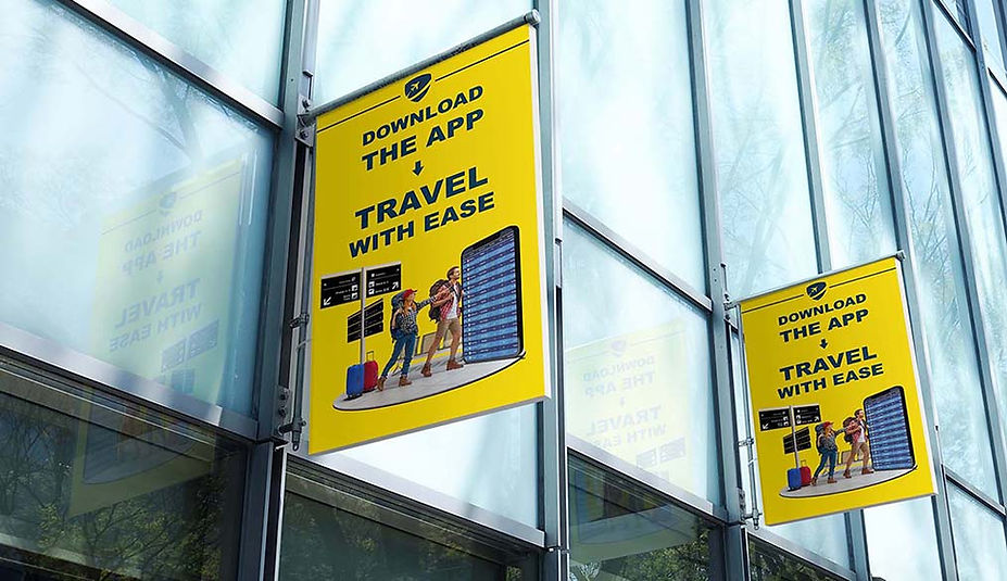 Two yellow promotional banners on building, 'Download the app & travel with ease'