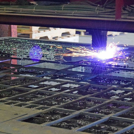 Industrial plasma cutter sparks during steel fabrication