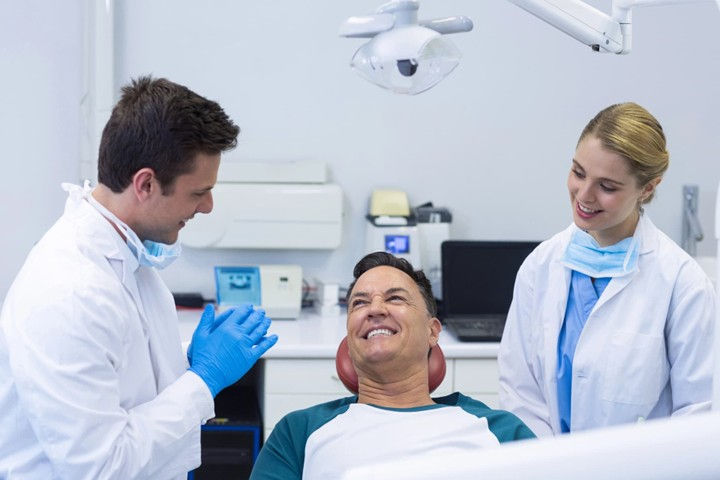 Dental implant consultation with patient and dental team in clinic