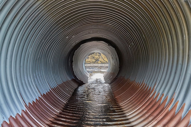 Inside of a corrugated sewer pipe with water