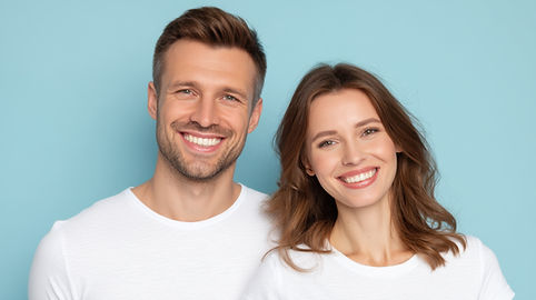 Smiling man and woman showing healthy white teeth.