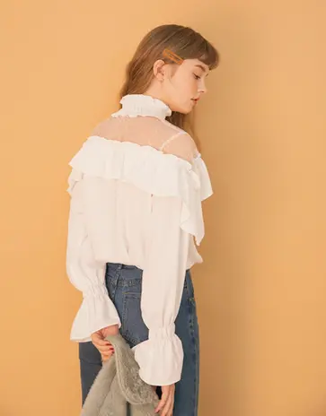 Young woman in white ruffled off-shoulder blouse with lace detail.