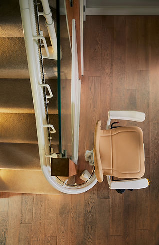 Beige Atlas Curved Stairlift installed on a wooden staircase for accessibility support