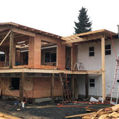 Building a two-story home addition with wooden framework and a ladder.