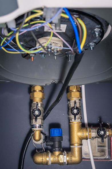 Close-up of water heater wiring and plumbing connections