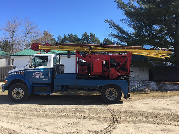 Blue and white well drilling rig truck