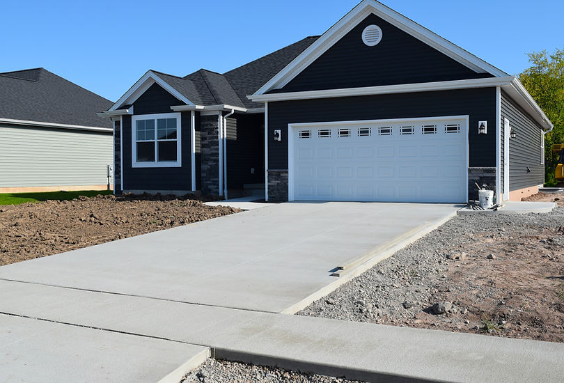 Newly paved concrete driveway for a modern dark house