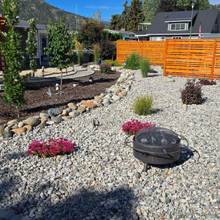 Landscaped backyard with gravel, fire pit, and pergola.