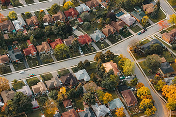 Aerial view residential neighborhood with many houses and autumn trees.