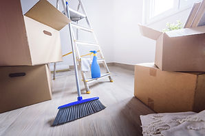 Broom and moving boxes in a bright, empty room