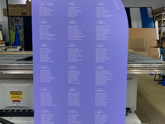 Curved purple event sign with white text, possibly a seating chart