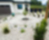 Modern xeriscape front yard with gravel and native plants.