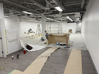 Empty commercial space under renovation, visible tools and materials on the floor.