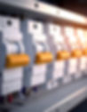 Row of electrical circuit breakers with yellow switches.